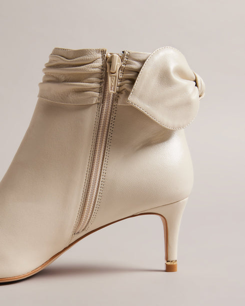 YONAS-Boots-Prepare To Make A Statement With Every Step. The Yonas Boots Can Effortlessly Transition From Day To Night From Office To Evening Events. Their Slim Heel Provides A Graceful Lift Adding A Feminine Touch To Your Stride While Maintaining Comfort And Stability. Ankle boots Smooth leather Pointed toe Slim heel Zip fastening Bow heel embellishment Ruched trim- Ted Baker Romania